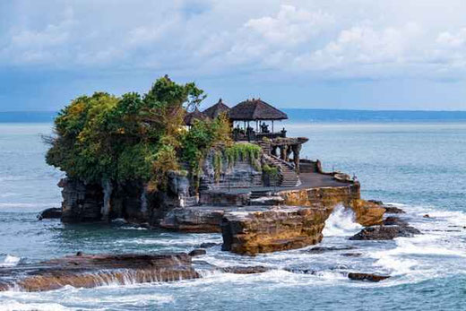 El templo Tanah Lot rodeado por el mar mientras las olas cubren el camino de acceso.
