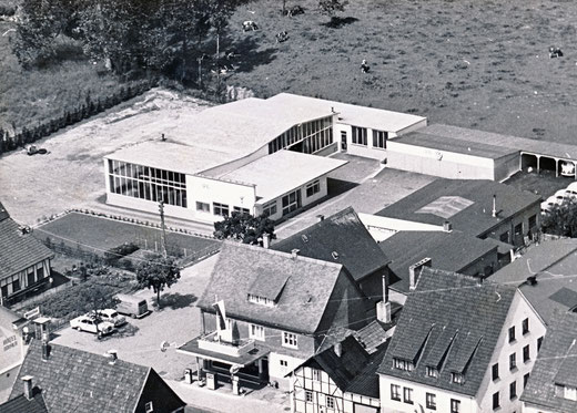 Der Firmenstandort Eslohe in den sechziger Jahren mit der neu erbauten Werkstatthalle, vorn die ESSO Tankstelle.