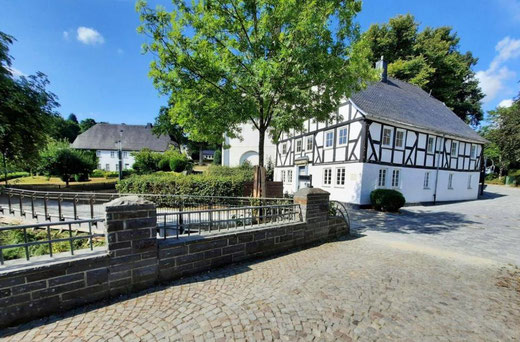 Das Esleven'sche aus, im Hintergrund das Pfarrhaus (aus dem Werbeprospekt 2024)