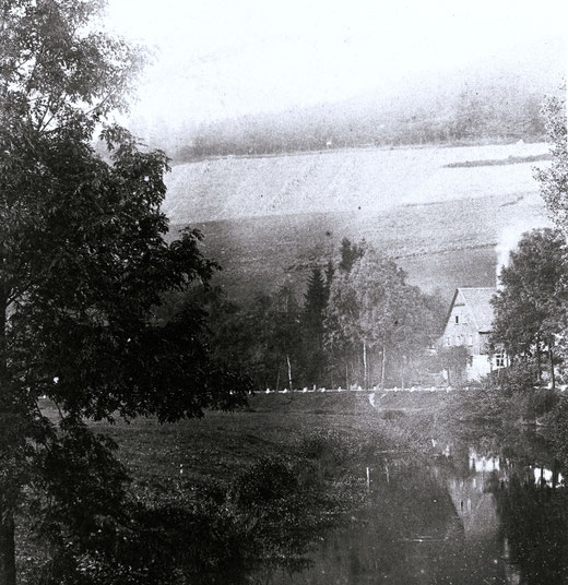 Die Wennestraße führte bis 1910 am Haus des Schreiners Bauerdick vorbei. Dann musste das Anwesen dem Bahnbau weichen. Man erkennt gut die weiß getünchten Begrenzungssteine der Wennestraße. Im Vordergrund fließt die Wenne.