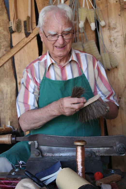 Ferdinand Rentmeister bei der Arbeit. Das Foto entstand auf einem Markt, dort wo er nicht nur seine Waren anbietet, auch sein Handwerk vorstellt.