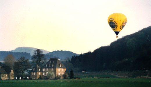 Ein moderner Heißluftballon auf seiner Fahrt über dem Wennetal bei Gut Wenne