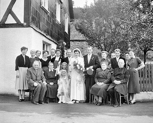 Hochzeit am 13.09.1955 der Eheleute Friedhelm und Else Schulte, geb. Sapp. Sitzend v.l.n.r.: Fritz Schulte, Franziska Schulte, Josefina Sapp, Pfarrer Karl Stolte, stehend: die Geschwister des Paares beider Seiten mit ihren Partnern.