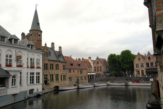 le barche nel canale di Bruges, con sfondo le case di mattoni rossi tipiche del Belgio