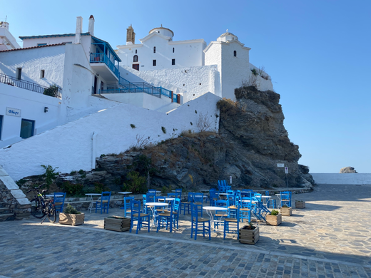 ristorante sul porto di Skopelos con tavolini blu e sfondo roccioso bianco