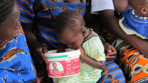 Un bambino cerca il cibo nel secchio che deve ancora essere riempito