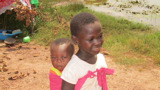 I bambini delle donne al lavoro. Sulla sinistra la bacinella di plastica dove dorme il più piccolo