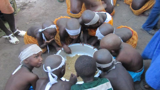I bambini del fanado mangiano del riso prima di lasciare la capanna
