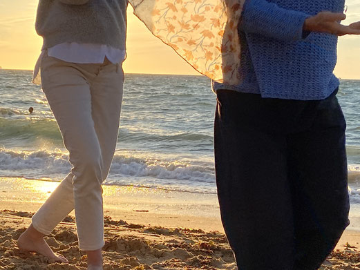 Zwei Frauen machen die Taichi-Kurzform am Strand