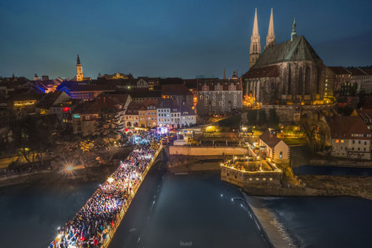 Blick von oben über die Altstadtbrücke Görlitz-Zgorzelec zum ersten deutsch-polnischen Christkindelmarkt in der Europastadt Görlitz-Zgorzelec. Das Foto wurde nach Einbruch der Dunkelheit aufgenommen. Die Altstadtbrücke ist feierlich beleuchtet.