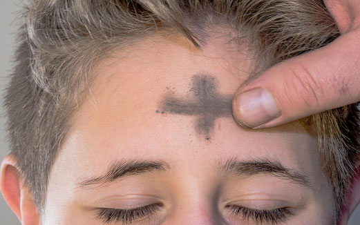 Es wird ein Aschekreuz auf die Stirn gezeichnet.