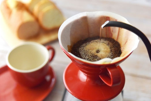 出勤前の食卓。カッティングボードに並べられたパン。ドリップコーヒーにお湯を注ぐ。