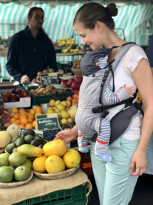 Auf dem Wochenmarkt einkaufen mit Baby für gesunde Ernährung in der Stillzeit. Frisches Obst.