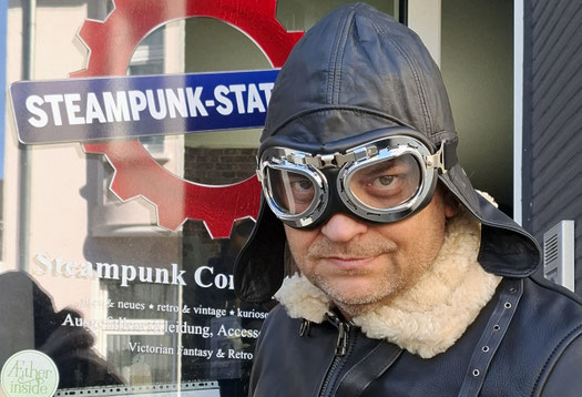 steampunk-flieger-outfit-mit-fliegerbrille-vor-ladengeschaeft-eingang-steampunk-station-bochum