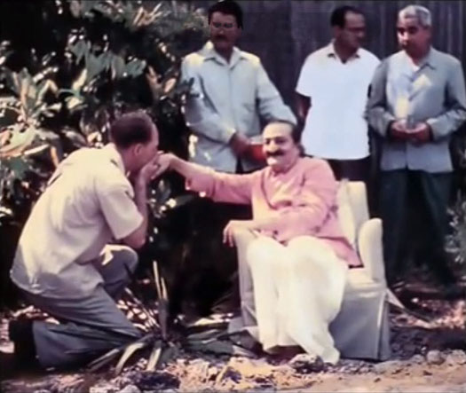 1958 : Darwin Shaw kissing Baba's hand inside the compound. The men mandali behind Baba are ; ( L-R ) Eruch Jessawala, Nariman Dadachanji and Adi K. Irani