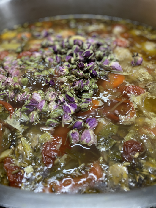 Schwimmende Rosenblütenknospen während des mehrstündigen Kochprozesses.