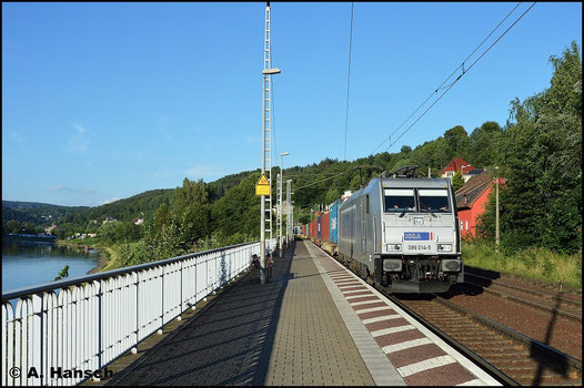 386 014-5 zieht vor der Kulisse der Elbe ihren Containerzug durch den Bf. Königsstein (20. Juli 2015)