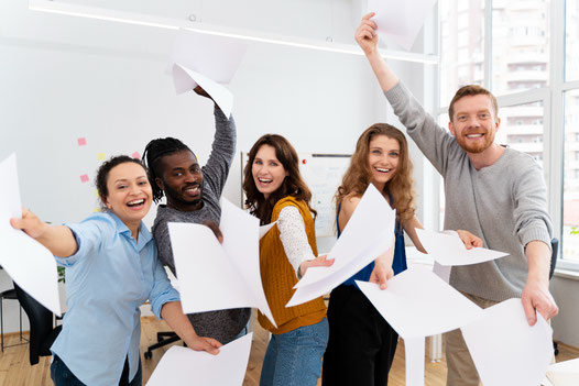 A group of students holding papers and smiling, symbolizing engaging and interactive Spanish lessons with artificial intelligence.