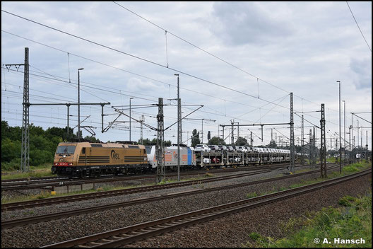 185 597-2 stellt mit ihrer goldenen Lackierung eine Besonderheit dar. Am 5. August 2023 zieht sie Wagenlok 186 299-4 und einen Autozug durch Luth. Wittenberg Hbf.