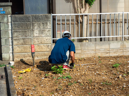 調査地点の位置出しを行っています。通常は建物の4隅と中央の5箇所を測定します。