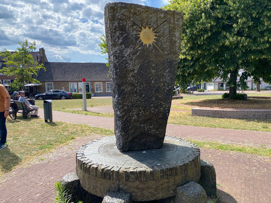 monumento dedicato a Vincent van Gogh in centro a Neuenen fatto con una lastra di roccia basaltica del Sud della Francia con un sole dipinto sopra e alla base una ruota 