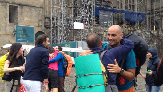 Pilgrims hugging each other at their arrival in Santiago