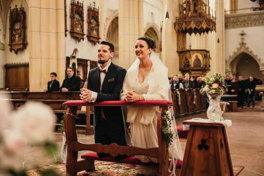 Florian Fredlmeier Fotografie, Fotograf, Neuötting, Hochzeitsfotografie, Hochzeiten, Brautpaar, Kirche, Trauung, Knien, Warm, Herzlich, Echt, Blumen, Anzug, Brautkleid, Stadtpfarrkirche Neuötting