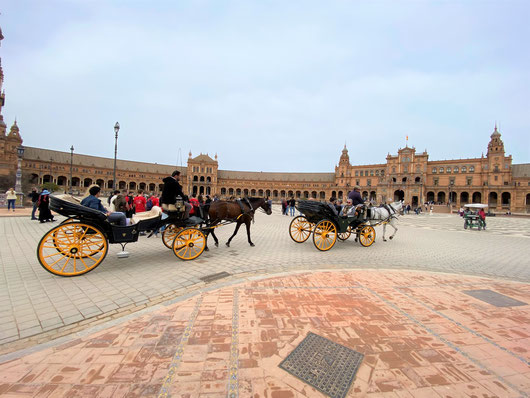Siviglia, Esplanade de plaza de Espagna con carrozze con ruote gialle e cavalli che portano in giro turisti