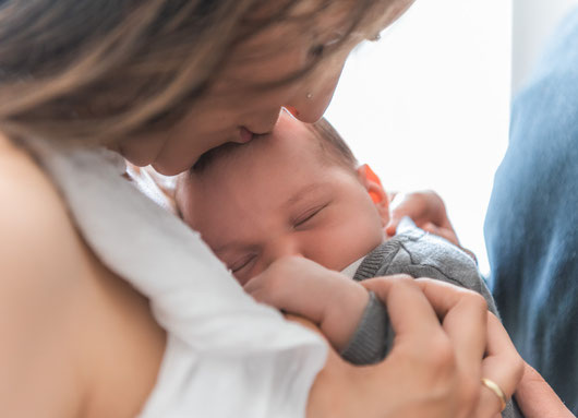 Babyfoto zu hause - Mama küsst Baby