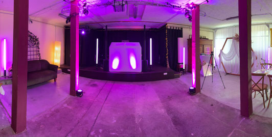 Eventlocation Pflanzeneck Hannover – stilvoll dekorierter Raum mit Bühne, DJ-Pult und Ambientebeleuchtung für Hochzeit oder Feier