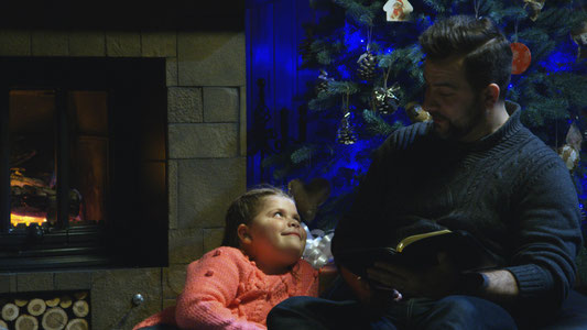 Wie dieser Vater lesen viele Eltern ihren Kindern die Weihnachtsgeschichte vor oder erzählen sie.