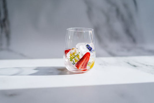 カフェオレのマグカップのうえにおかれたくまのクッキー。手帳とボールペン。小さな小包。観葉植物のグリーン。