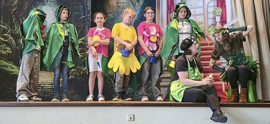 Erst mit dem Finden der Instrumente erstrahlte die Sonne und die Blumen (gespielt durch sechs Kinder) konnten blühen. Sie wurden durch Theresa Bub (sitzend) und Raphaela Stürmer begleitet. © Foto: Kiara Winter