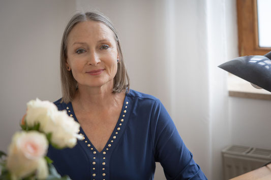 Ditte Ferrigan-lächelnd am Schreibtisch Hypnosetherapeuting und Heilpraktikerin für Psychotherapie 