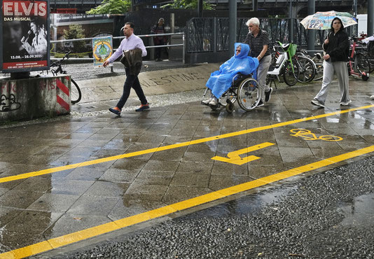 Berlin, Streetfotografie, Fahrrad, Straße, Urban, Rollstuhl, Schwerbehindert,Schirm, Elvis, Plakat, Sonne,Spiegelung, Pfeil, Anzug