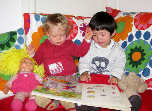 Die Kinder schauen sich ein Bilderbuch zusammen an