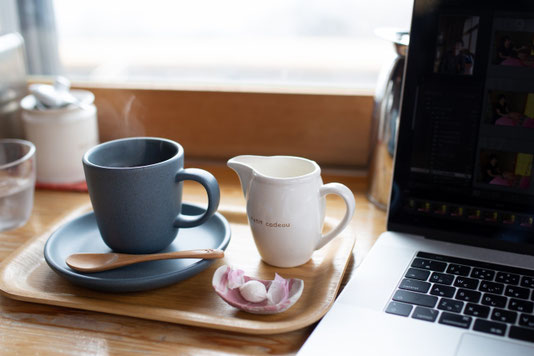 朝のカフェの店内。テーブル席の横のブラインドから朝日が差し込んでいる。