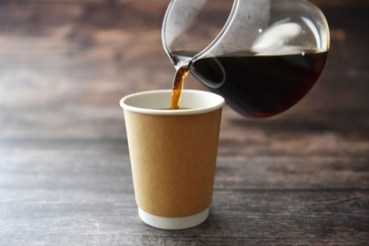 紙コップにコーヒーがサーバーから注がれている。
