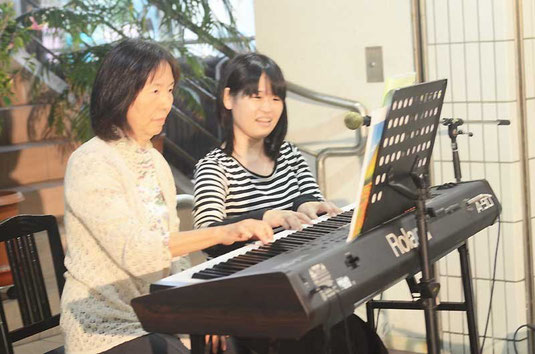 軽やかな電子ピアノの音色を響かせる宮地さん(右)と生徒=ライブスポットななサン丸