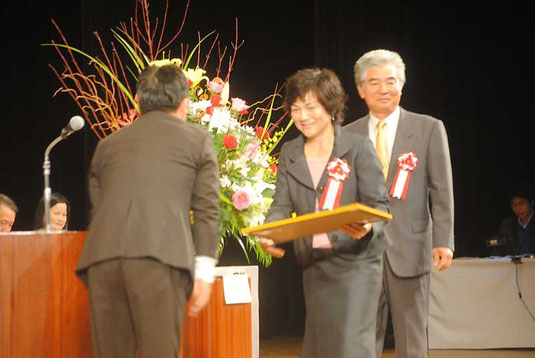 北川会長から表彰される八重山地区の山里世紀子さん、野底一彦さん=30日午後、市民会館大ホール