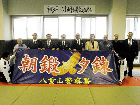 「朝鍛夕錬」の文字が入った激励旗が贈られた=八重山署