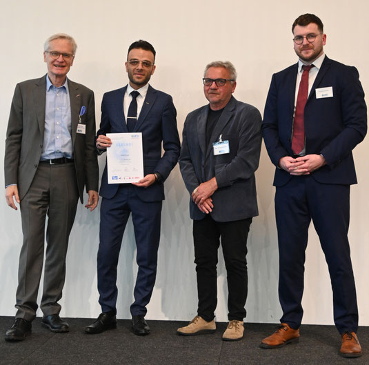Absolvent mit Urkunde im Gruppenfoto