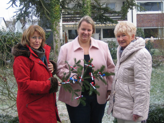 Das Foto zeigt die Pfarrerin Dr. Erichsen-Wendt von der evangelischen Kirche bei der Geldübergabe - passend zur Weihnachtszeit mit Tannenzweig - durch Petra Ensberg und Barbara Geisler vom Nidderauer Tauschring.