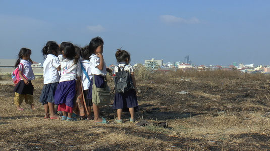 Ces enfants scolarisés qui regardent au loin la ville de Phnom Penh ont sous leurs pieds l'ancienne décharge aujourd'hui fermée.