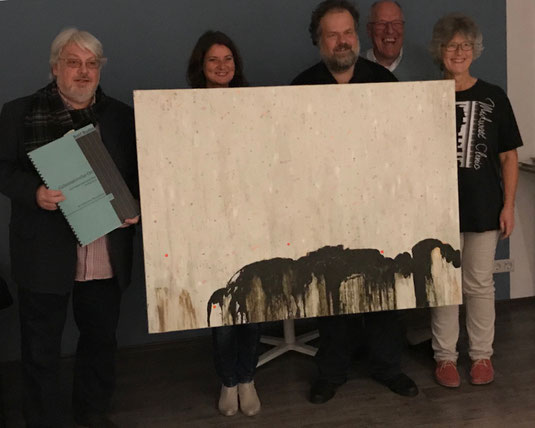 Auf dem Bild hält Rolf Rudin die Partitur seines Werks "Geheimnisvoller Ort", daneben sieht man Dirigentin Andrea Hunkel, den Maler Jens Joneleit, Lothar Mark von der Hospiz Stiftung Rotary Rodgau und rechts Dirigentin Angela Groh