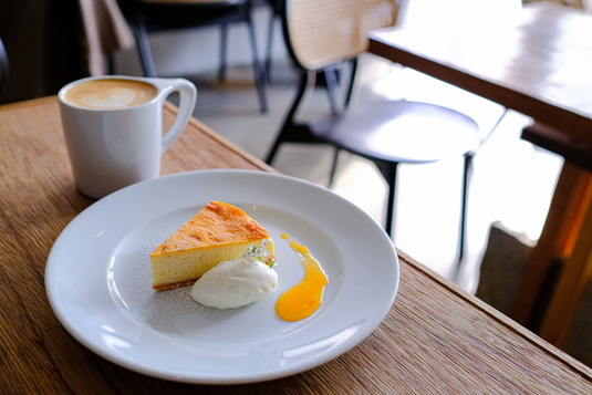 伝票を手に取り注文をとるエプロン姿のカフェ店員。