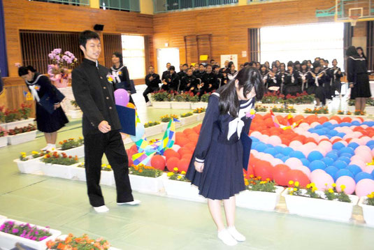 式を終え、来賓席に頭を下げる卒業生=10日午前、白保中体育館