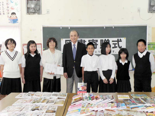 図書、書架を寄贈した桃原さん(中)=石垣小