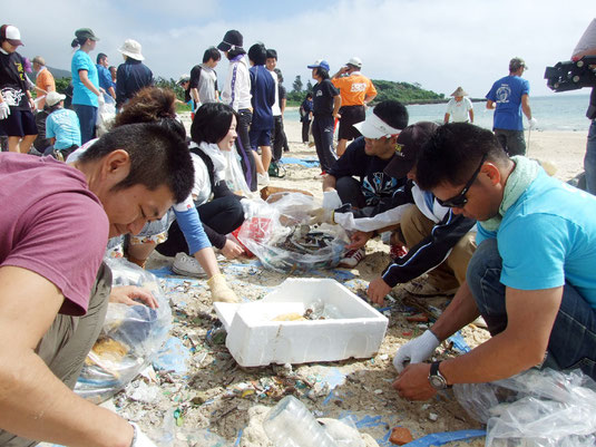 拾い集めたごみを分別する参加者たち=4日午前、伊原間海岸