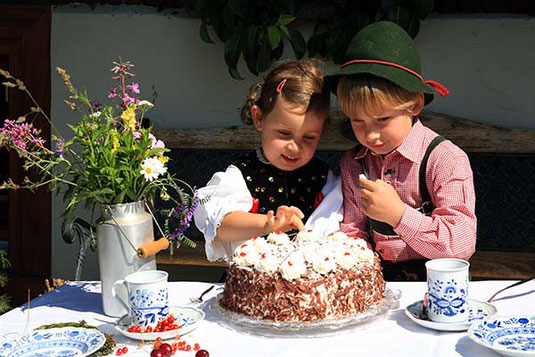 Zwei Schwarzwaldkinder essen eine Schwarzwälder Kirschtorte